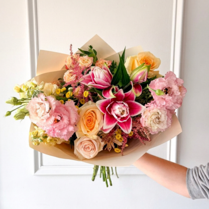 A summer bouquet of lilies, roses, and lisianthus wrapped in premium paper for delivery or pickup in Edina, Minneapolis and Minnetonka. 
