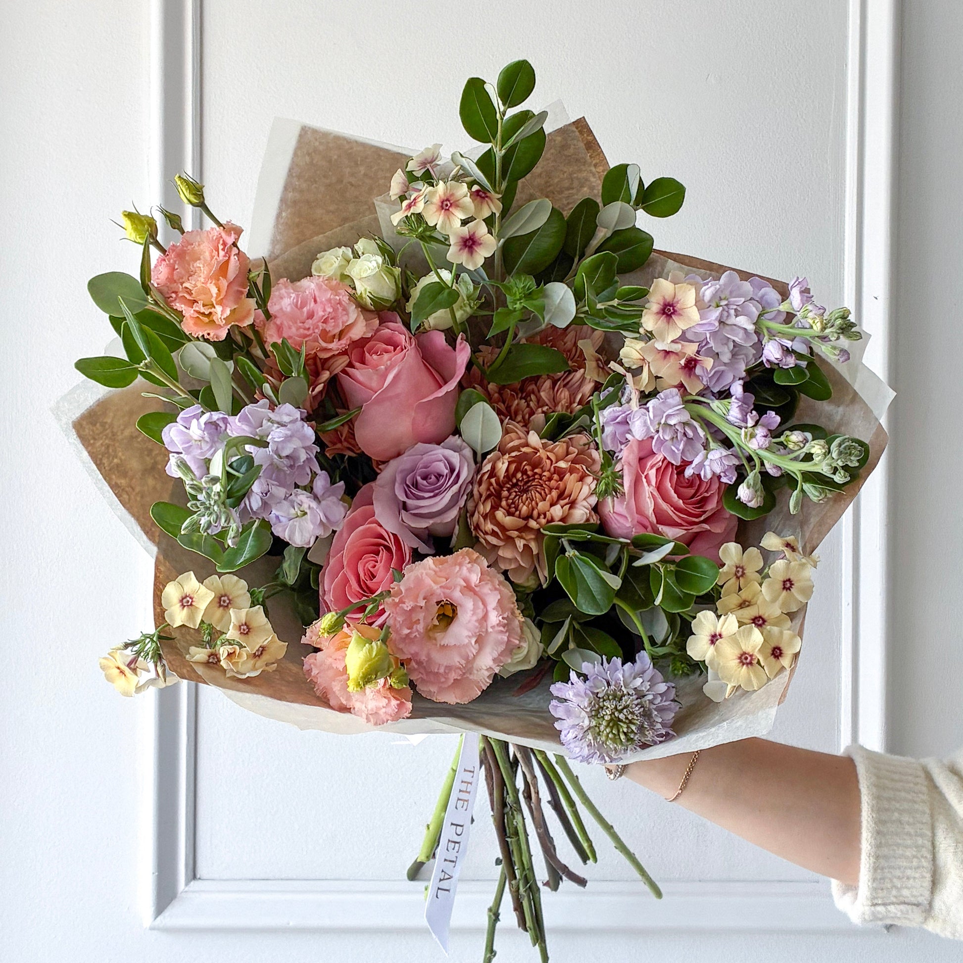 Bouquet of luxury flowers including lisianthus, roses, and phlox hand-tied in our signature wrap for pickup or delivery in Minneapolis, Edina, Plymouth, and Minnetonka.
