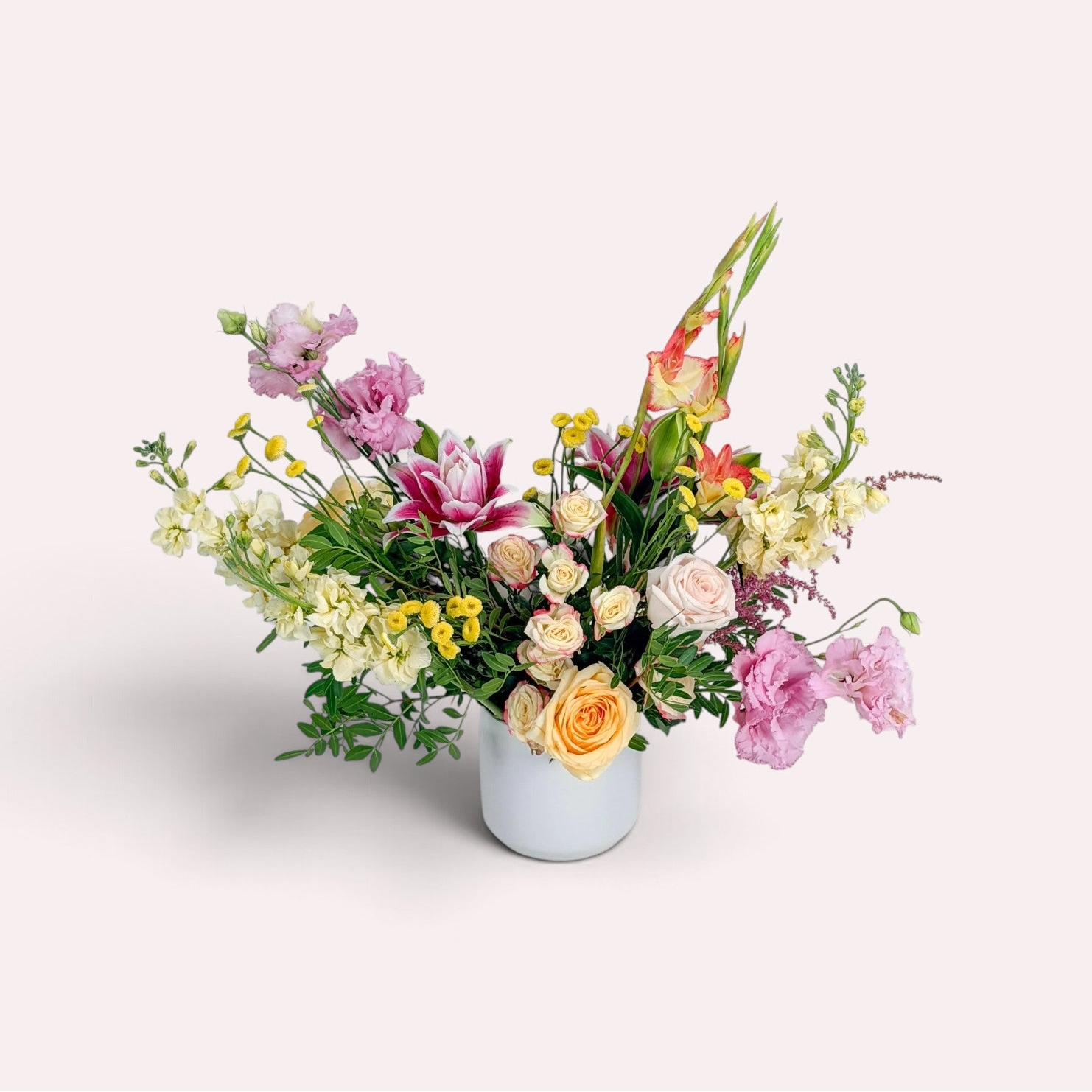 Colorful summer flower arrangement with mixed pink and yellow blooms in a white ceramic vase for Minneapolis flower delivery from The Petal.