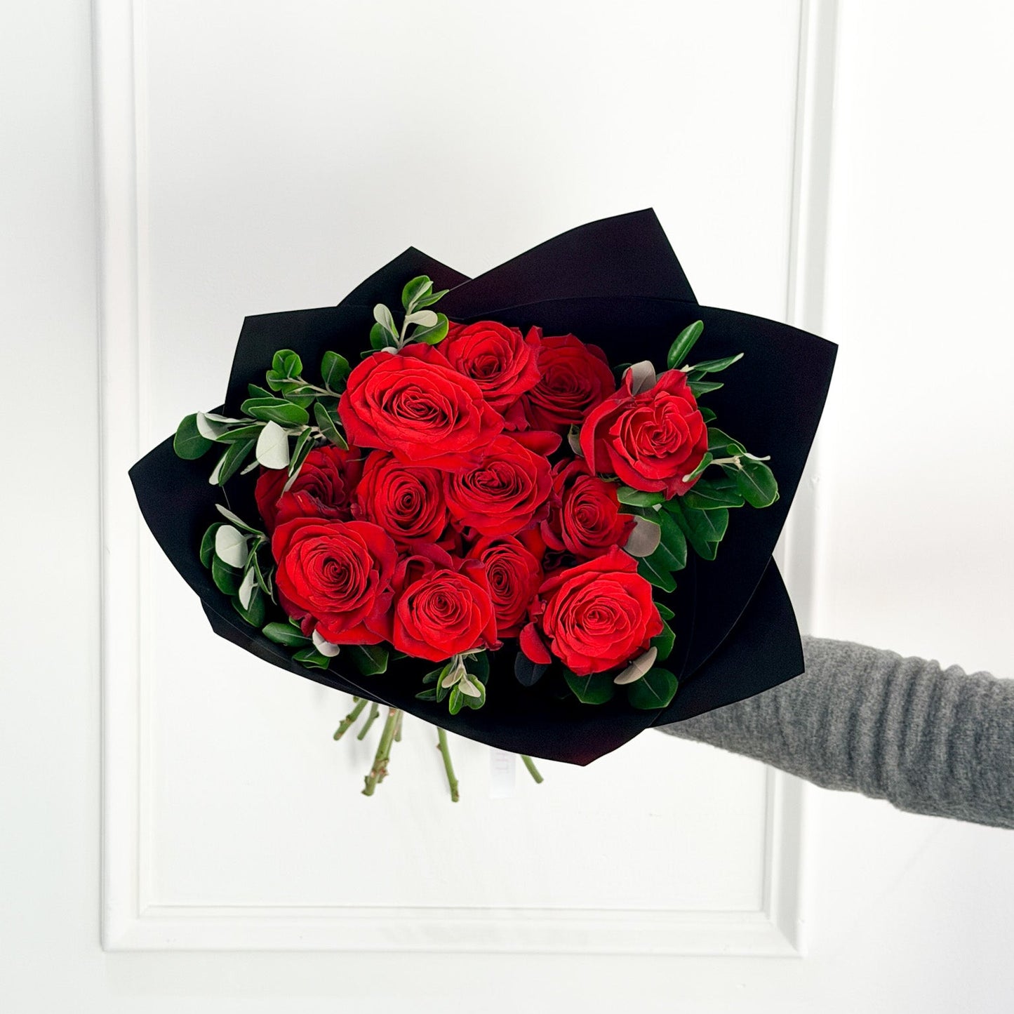 Romantic Valentine’s red rose bouquet with fresh greenery, elegantly wrapped in black premium wrap, serving Excelsior, Golden Valley, and Hopkins for local delivery.