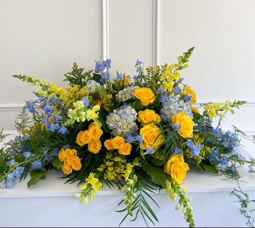 Luxury Classic casket spray featuring colorful seasonal blooms, elegant arrangement available for pick-up in Edina or delivery to Richfield, Hopkins, and Golden Valley