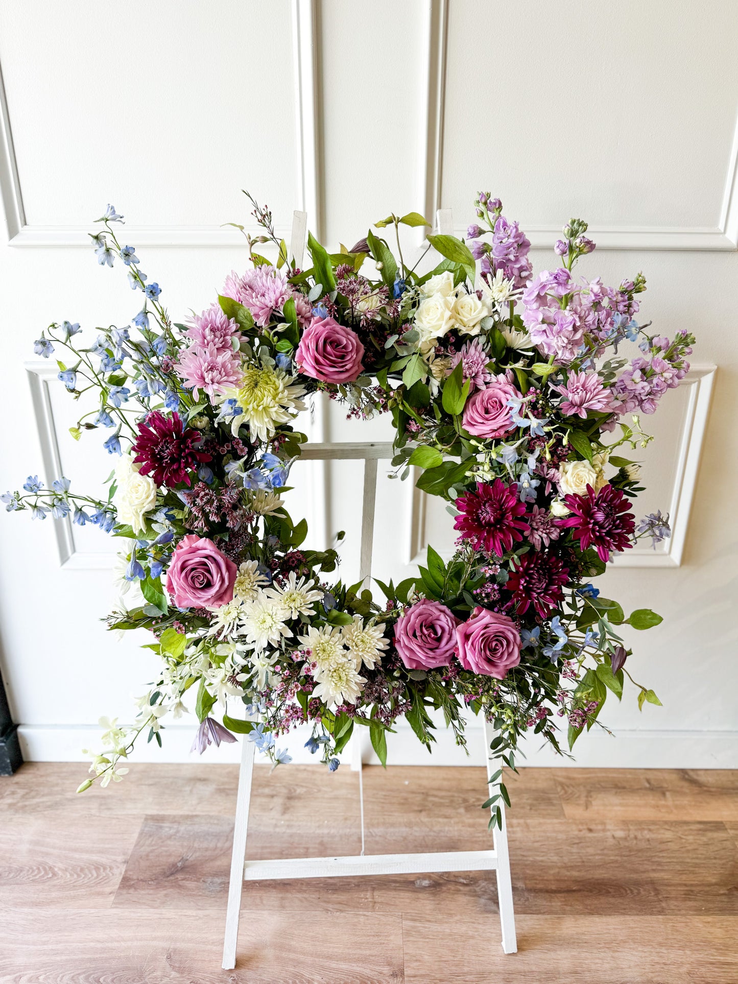 Premium Celebration of Life wreath on stand with seasonal blooms, elegant funeral floral arrangement, available for pick-up in Edina or delivery to Edina, Golden Valley, and Excelsior