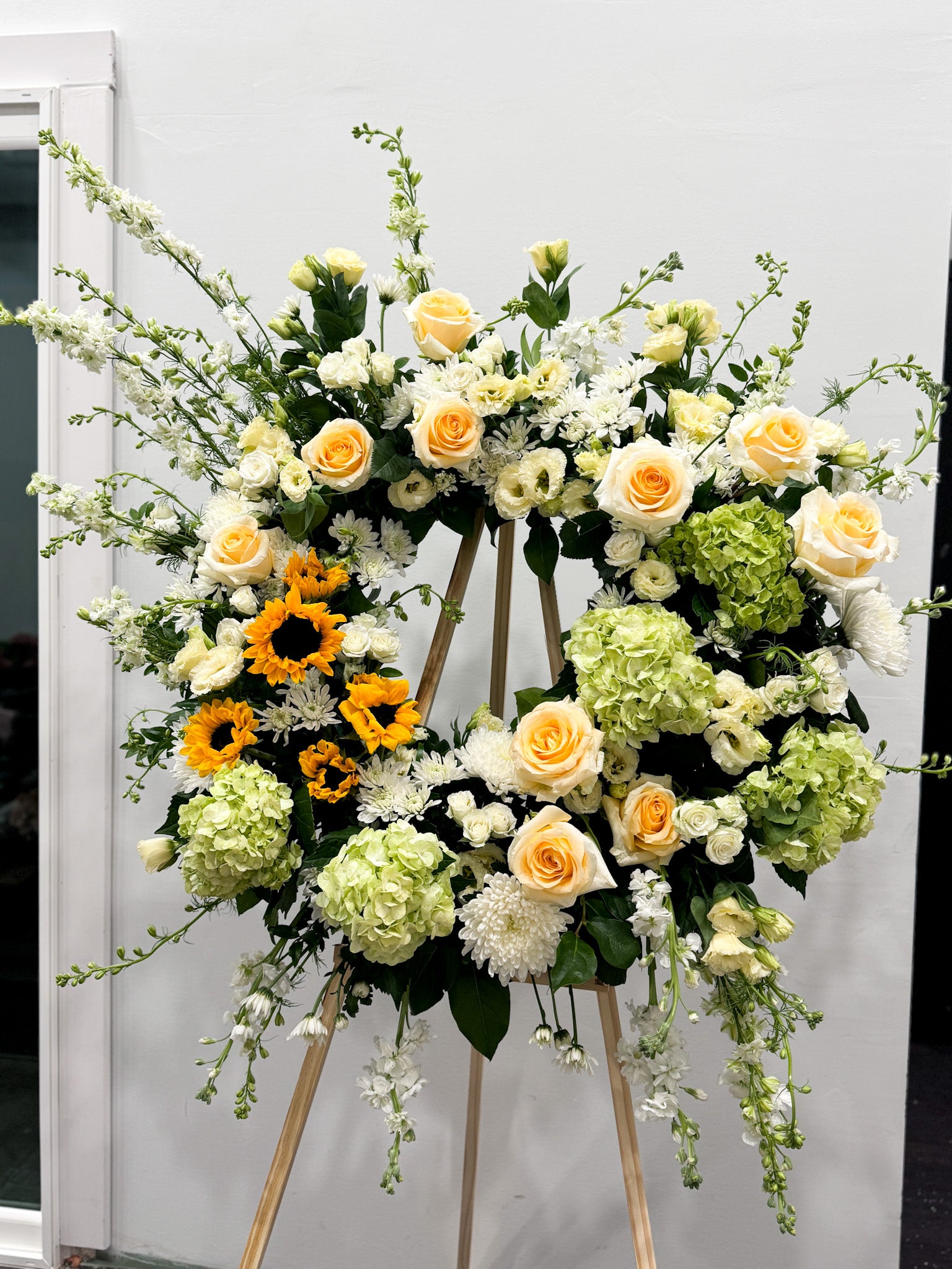 Signature wreath on stand with seasonal blossoms and garden-inspired arrangement, bespoke floral design, available for pick-up in Edina or delivery to Edina, Southwest Minneapolis, and Minnetonka