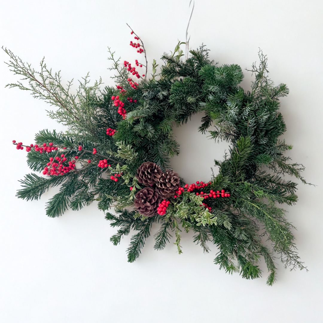 Premium Classic holiday wreath with evergreen foliage, bright red berries, and natural pinecones in an elegant garden-inspired design, perfect for holiday home décor or gifting, available for Edina pick-up or Minneapolis delivery