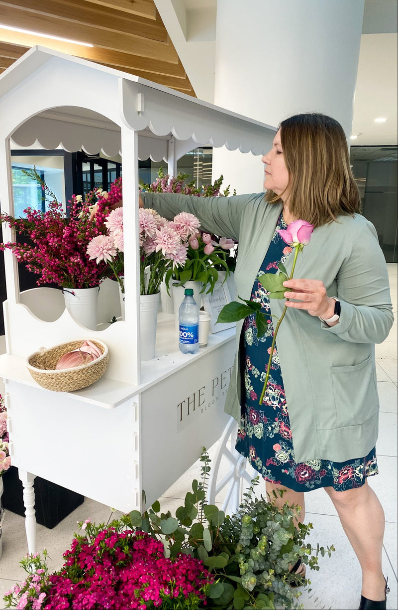 Lady picking flowers from The Petal Bloom Bar Cart for a staff appreciation event. 