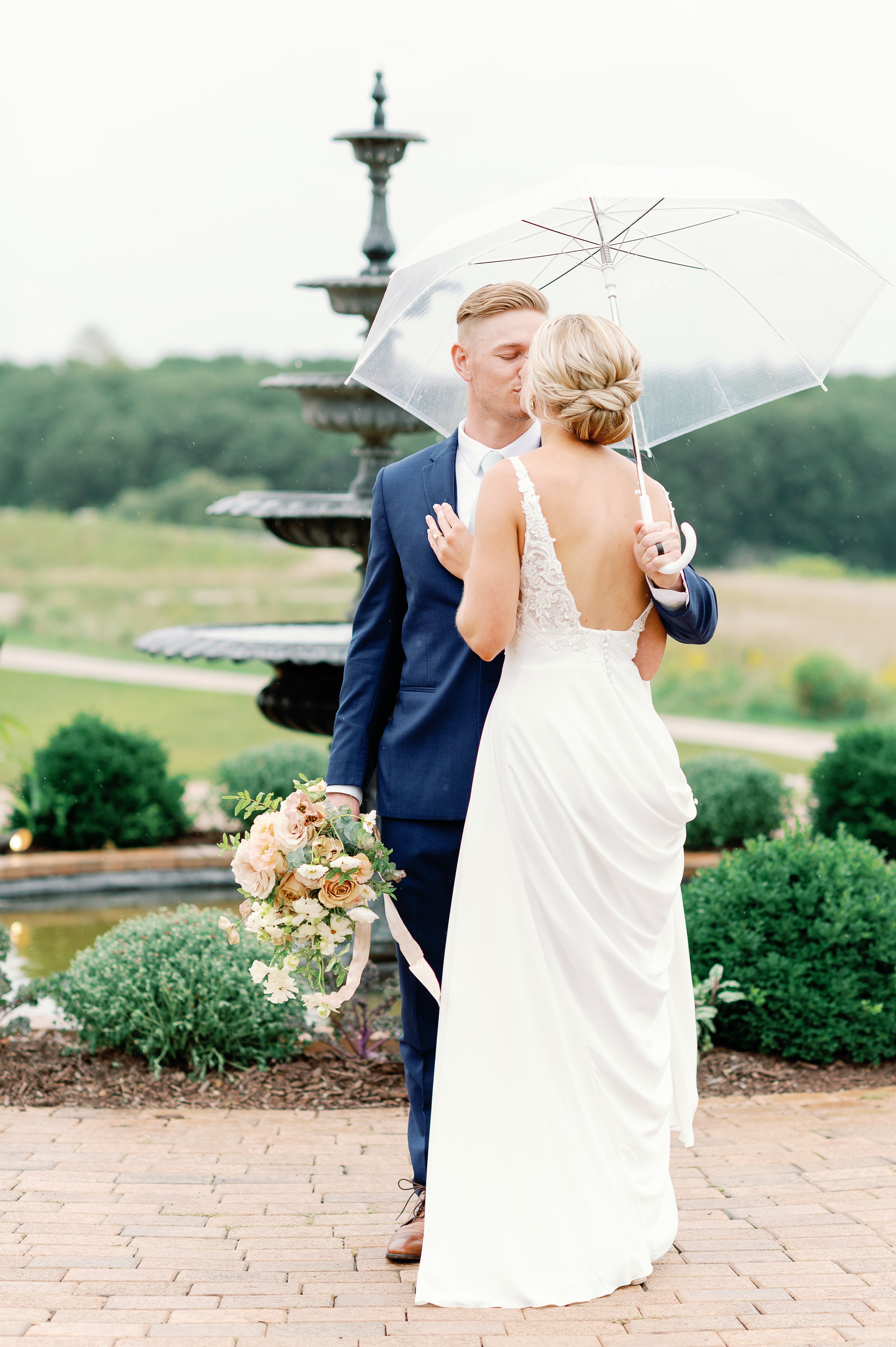 couple kissing in the rain by the fountain at edward ann estate bavaria downs 