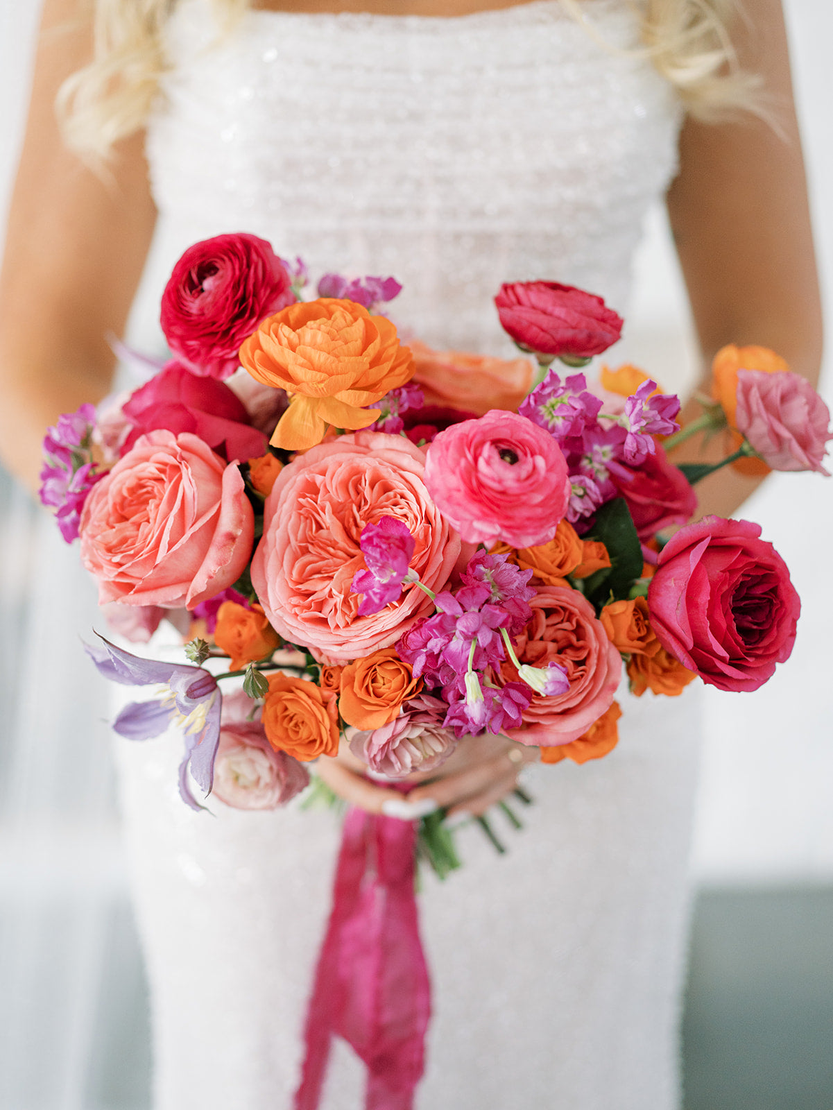 Orange and pink Bridal bouquet of garden roses, ranunculus, and clematis for a garden-style wedding in Minnesota