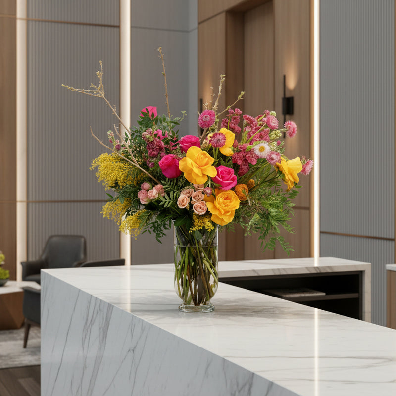 Colorful seasonal floral arrangement on a marble reception desk in an office setting. Corporate flower subscriptions for Hotels, businesses, corporate, luxury residences, Country Clubs in Minneapolis, Edina, Eden Prairie, Wayzata, and MInnetonka.