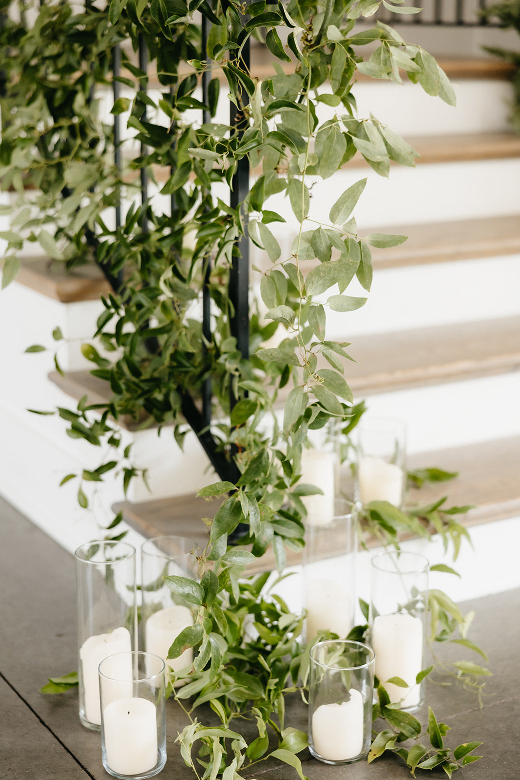 Decorative setup with greenery and candles on a staircase.