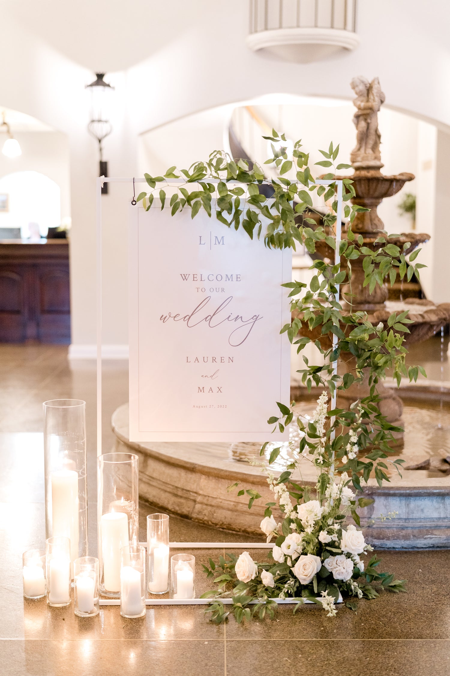 Wedding welcome sign in lobby of Lafayette club with greenery and candles.