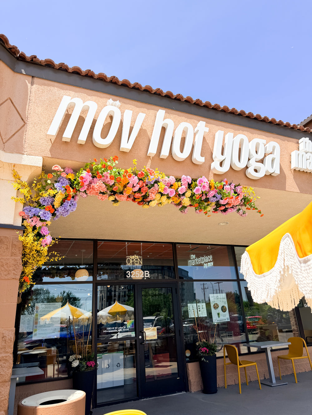 Exterior permanent floral installation on a storefront for hot yoga in Minneapolis designed by The Petal using premium silk flowers. 
