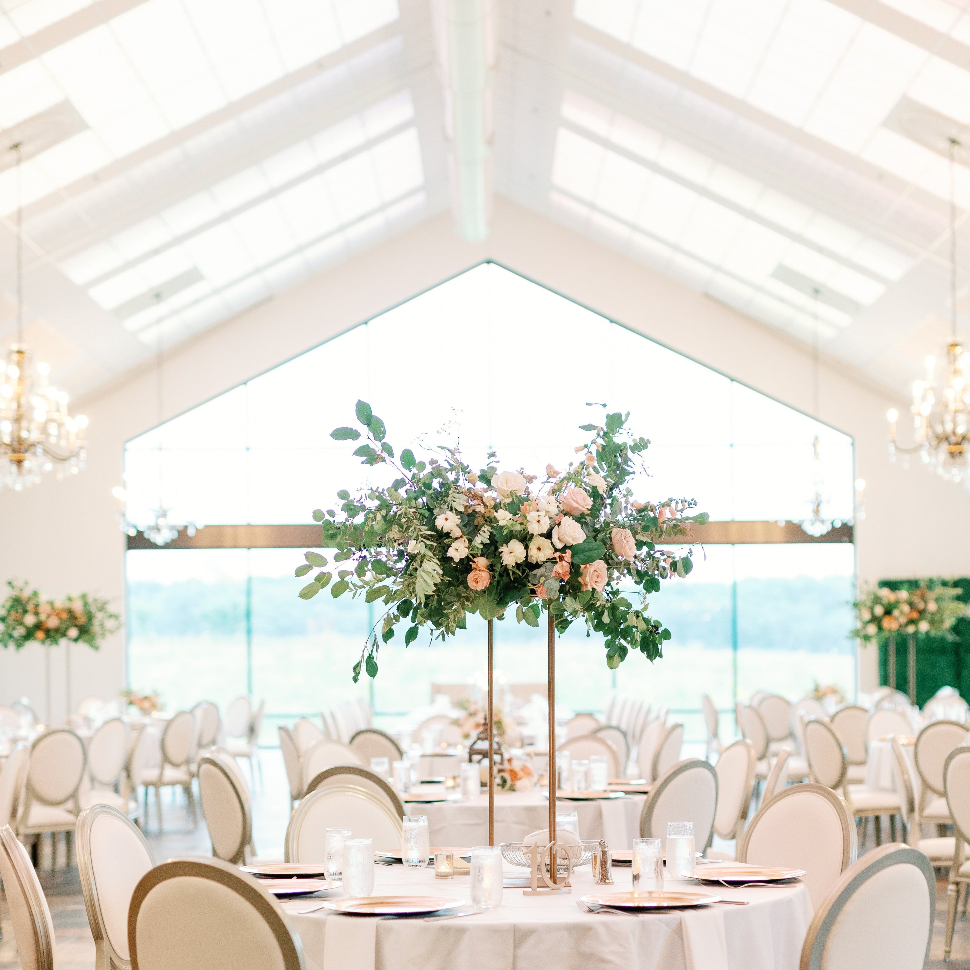Elegant wedding reception with tall centerpieces of peach flowers at bavaria downs by The Petal
