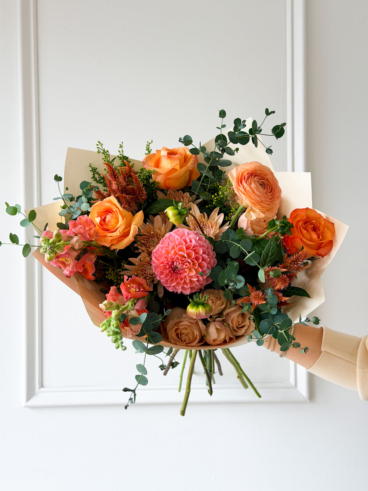Signature October bouquet featuring a warm palette of bright coral, dusty mauve, soft peach, and gentle orange blooms balanced with fresh green foliage. Available for pickup in-store in Edina, or local delivery across Minneapolis, Bloomington, and Eden Prarie.
