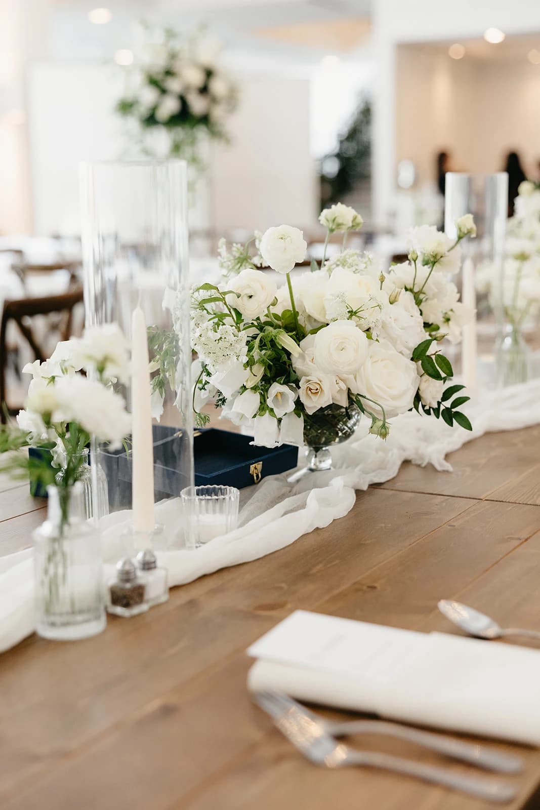 Classic white and green wedding flowers centerpiece and bud vases for the head table at a luxury wedding in Minneapolis by top florist, The Petal.