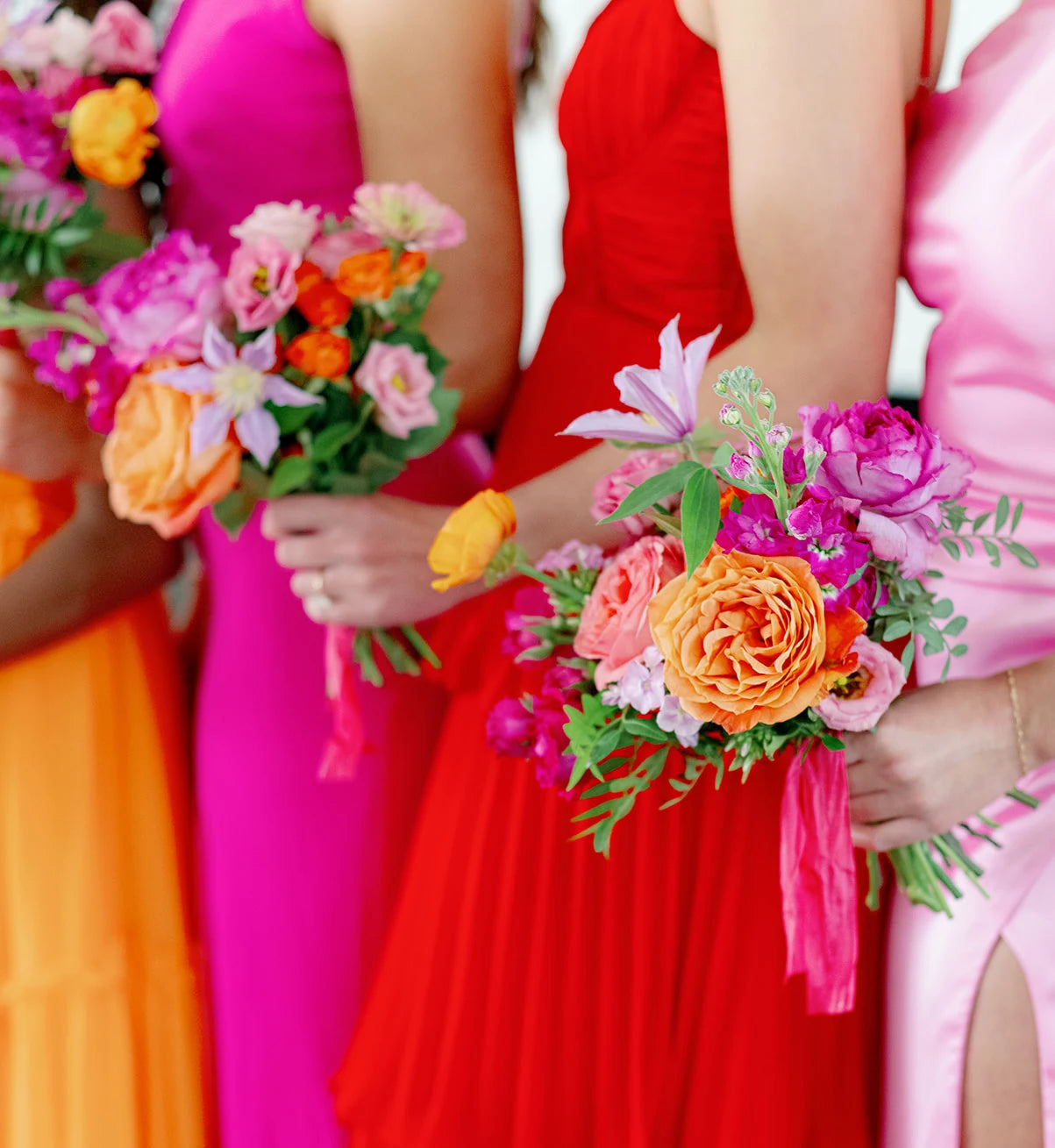 Colorful bridesmaids bouquets filled with garden roses, ranunculus, lisianthus and clematis tied with a silk ribbon by award winning minneapolis luxury florist, The Petal.