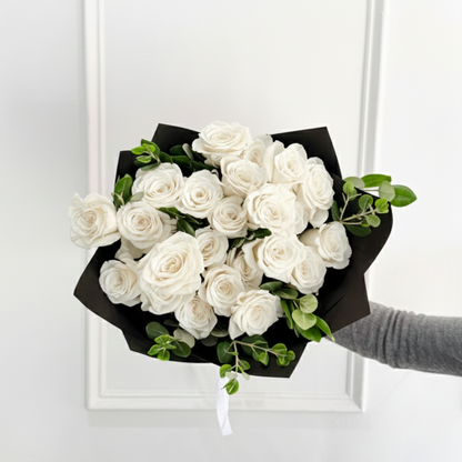 Hand-tied bouquet of white roses in black premium wrap, from a women-owned, small business. Shop local and enjoy Valentine’s Day delivery from your trusted Edina florist.