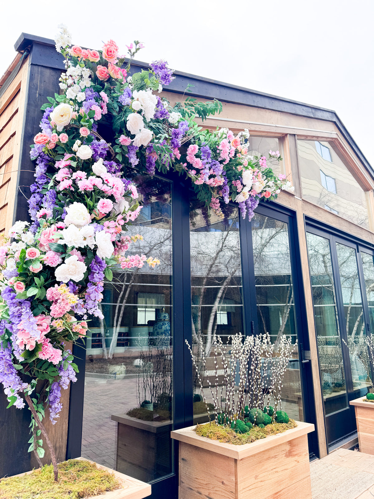 Floral installation of silk flowers climbing up exterior of a business in Edina, The Westin.